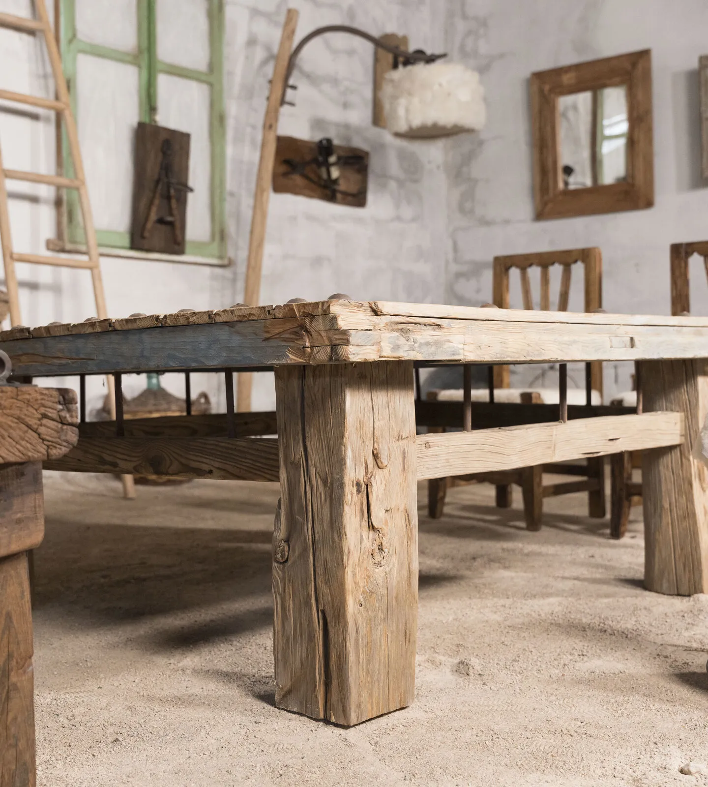 Mesa de tachuelas con canto azul y patas de viga en el taller